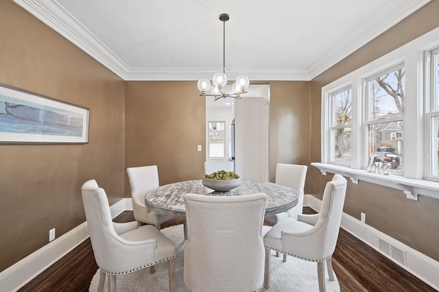 dining space with ornamental molding, an inviting chandelier, and dark wood-type flooring