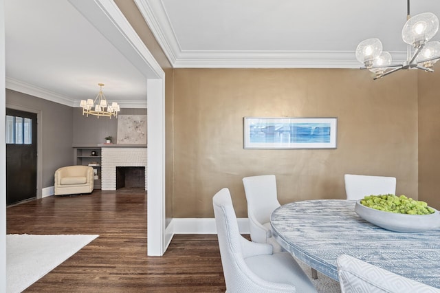 dining space featuring a chandelier, dark hardwood / wood-style floors, a brick fireplace, and crown molding