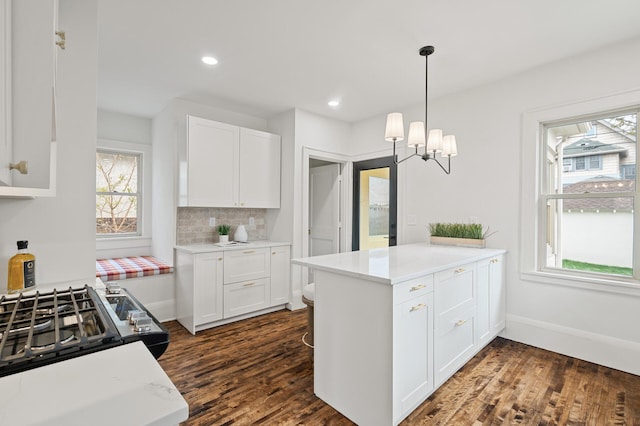 kitchen with dark hardwood / wood-style flooring, white cabinets, a healthy amount of sunlight, and decorative light fixtures