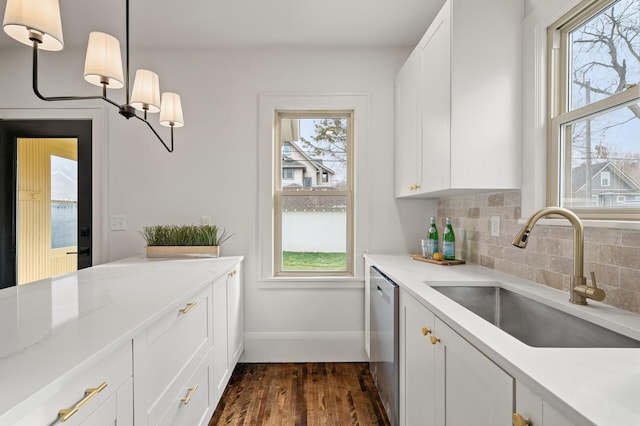 kitchen featuring dark wood-type flooring, sink, pendant lighting, dishwasher, and white cabinets