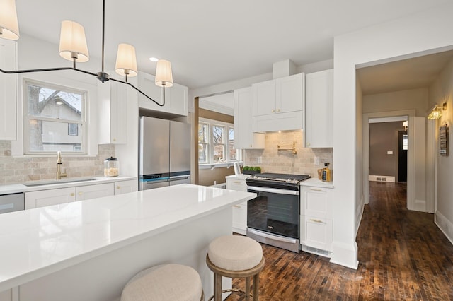 kitchen with stainless steel appliances, white cabinetry, a healthy amount of sunlight, and sink