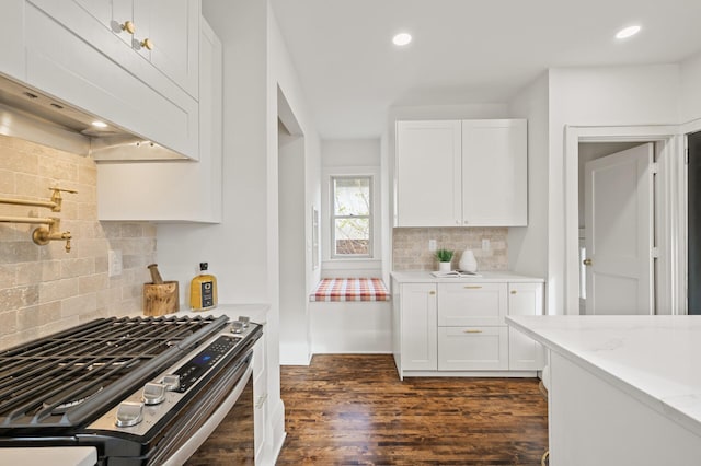 kitchen featuring dark hardwood / wood-style flooring, light stone countertops, stainless steel gas stove, and white cabinets