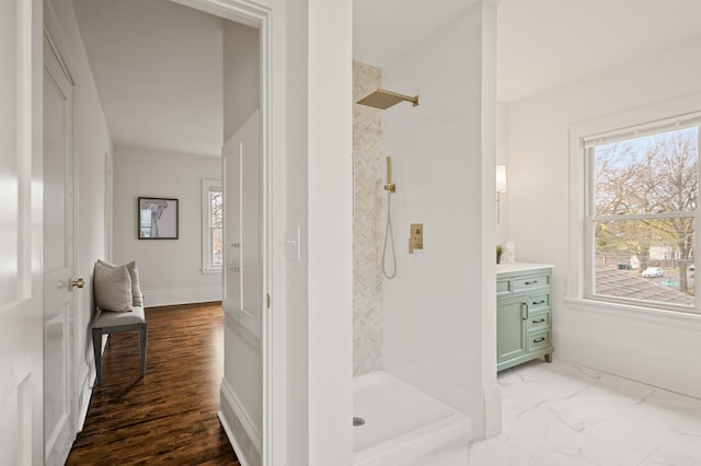 bathroom with a tile shower, hardwood / wood-style floors, and vanity