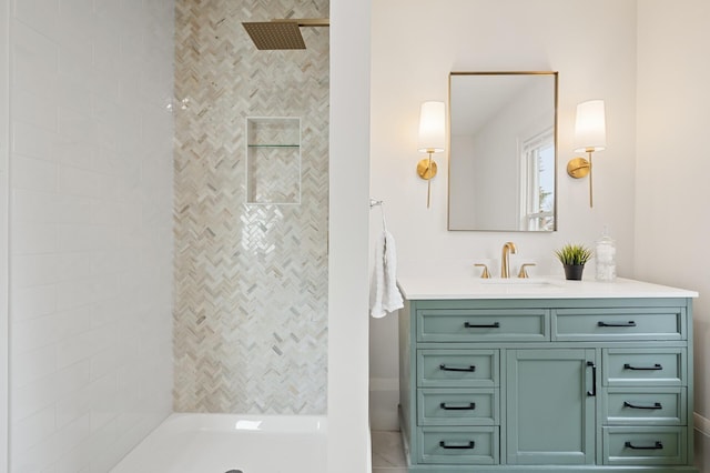 bathroom featuring tiled shower and vanity