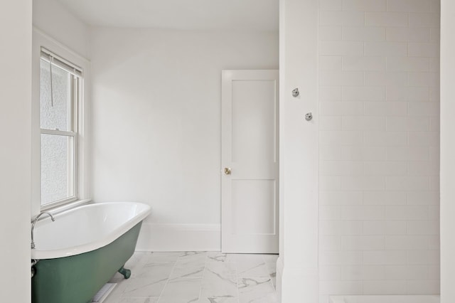 bathroom with a washtub and a healthy amount of sunlight