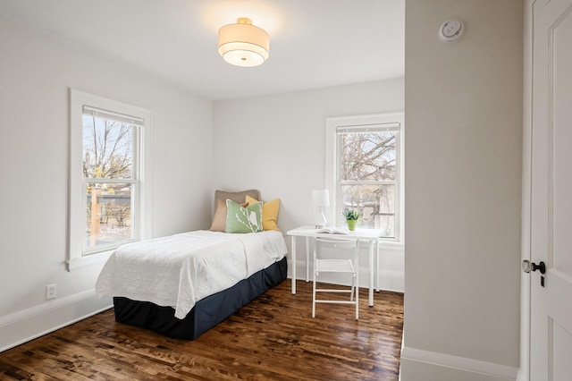 bedroom featuring multiple windows and dark hardwood / wood-style flooring