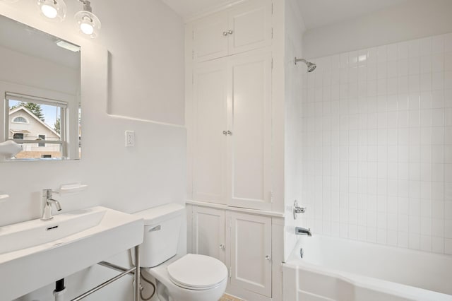 full bathroom featuring toilet, tiled shower / bath, and sink