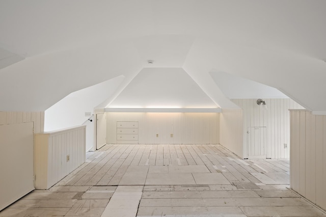 bonus room featuring wooden walls and vaulted ceiling