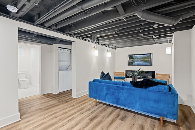 living room featuring hardwood / wood-style floors and stacked washer and clothes dryer