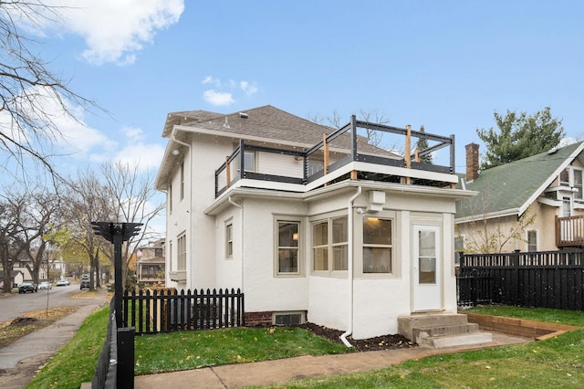 back of property with a balcony and a yard