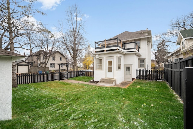 rear view of property with a balcony and a lawn