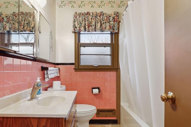 full bathroom featuring vanity, toilet, tile walls, and shower / bath combo with shower curtain