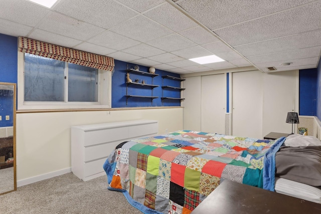 bedroom with a paneled ceiling and light carpet