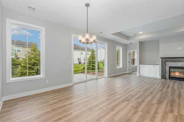 unfurnished living room with a fireplace, light hardwood / wood-style flooring, and a healthy amount of sunlight