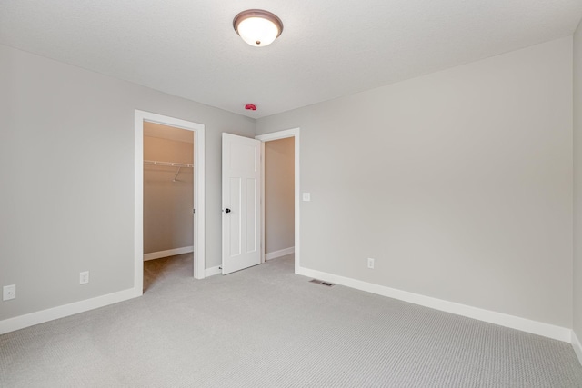 spare room with a textured ceiling and light carpet