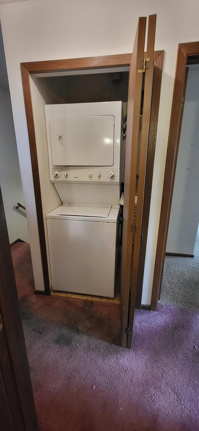 washroom featuring dark carpet and stacked washer / dryer