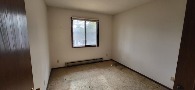 spare room with carpet, a textured ceiling, and a baseboard heating unit