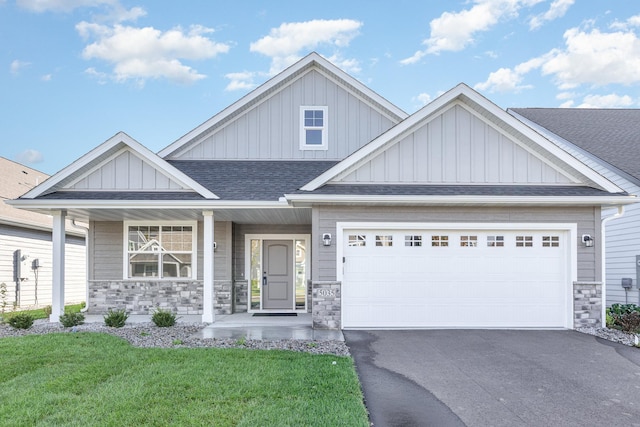 craftsman house with a porch, a garage, and a front lawn