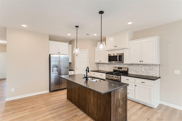 kitchen featuring a center island with sink, white cabinets, sink, light hardwood / wood-style floors, and stainless steel appliances