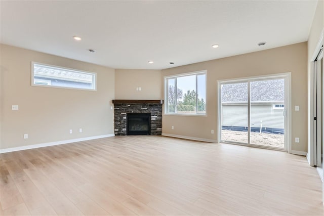 unfurnished living room with a fireplace and light hardwood / wood-style floors