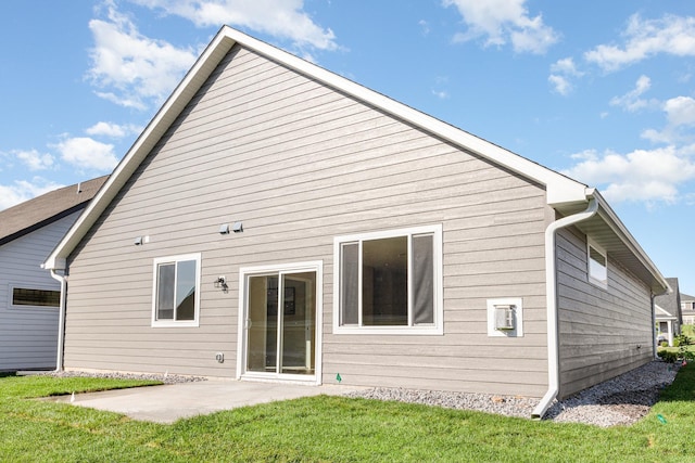 rear view of house featuring a patio area and a yard