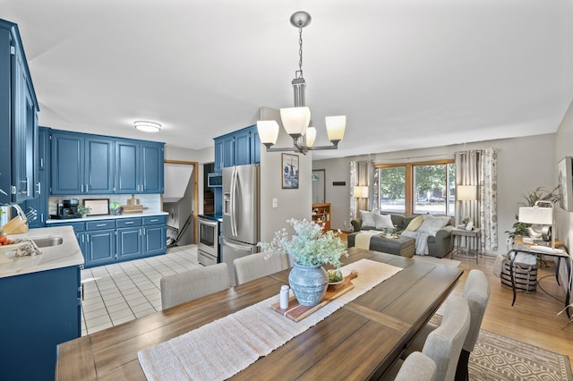 dining room featuring sink, light hardwood / wood-style floors, and a notable chandelier