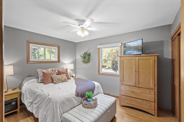 bedroom featuring ceiling fan, light hardwood / wood-style floors, and a closet