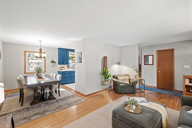 living room featuring a notable chandelier and light hardwood / wood-style floors