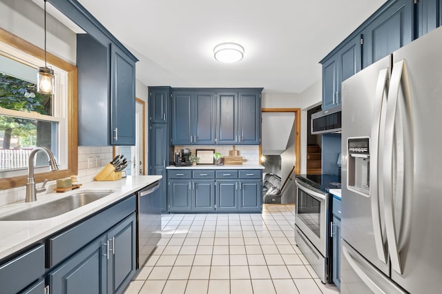 kitchen with decorative backsplash, sink, hanging light fixtures, and appliances with stainless steel finishes