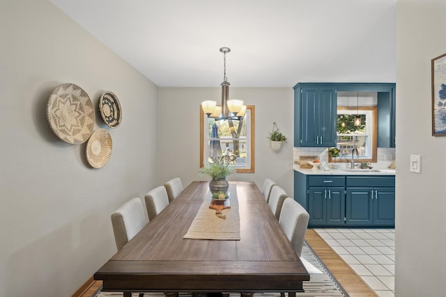 dining space featuring light tile patterned floors, sink, and a chandelier