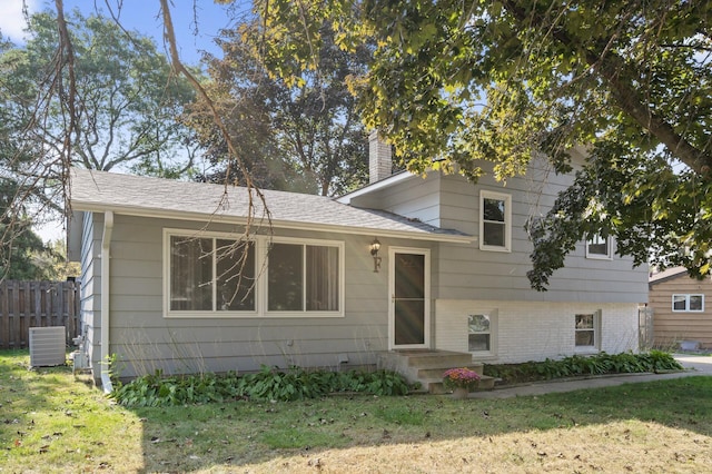 split level home with a front yard and central air condition unit