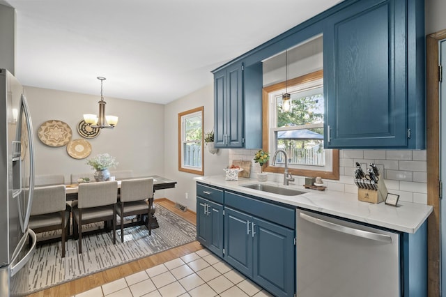 kitchen with light wood-type flooring, stainless steel appliances, blue cabinets, and sink