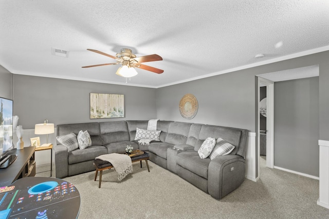 carpeted living room with a textured ceiling, ceiling fan, and crown molding