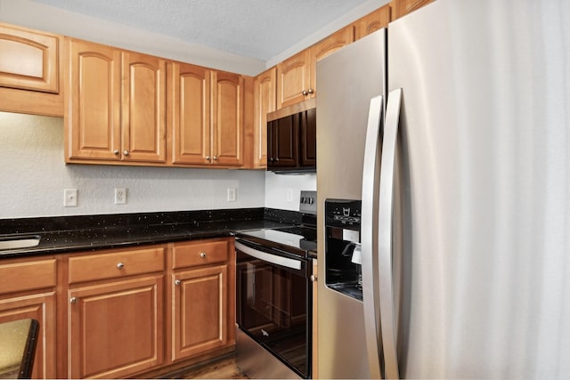 kitchen featuring hardwood / wood-style floors, dark stone countertops, stainless steel appliances, and a textured ceiling