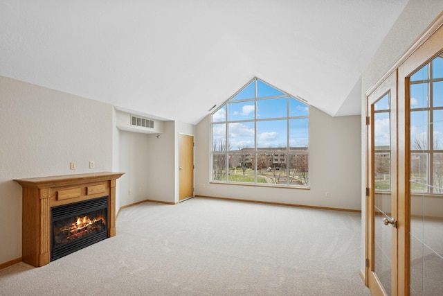 unfurnished living room with light carpet and lofted ceiling