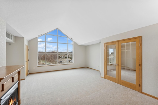 unfurnished living room featuring light carpet and french doors