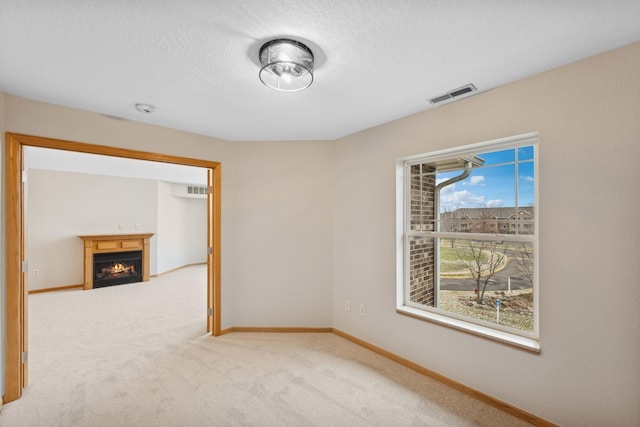 carpeted spare room featuring a textured ceiling