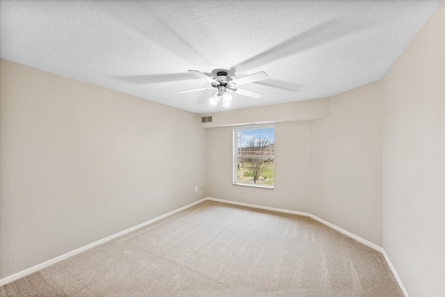 carpeted empty room featuring a textured ceiling and ceiling fan