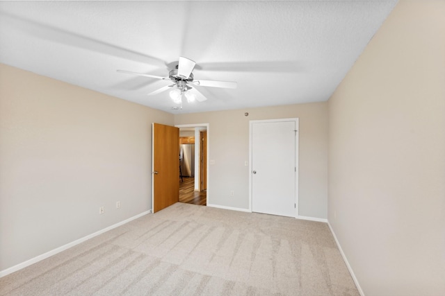 unfurnished bedroom with ceiling fan, a closet, and light colored carpet