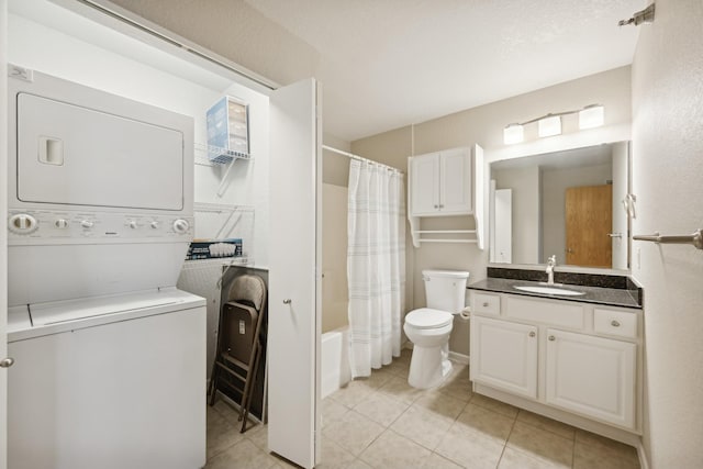 full bathroom featuring stacked washing maching and dryer, tile patterned floors, toilet, shower / bath combo with shower curtain, and vanity