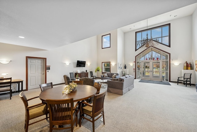 carpeted dining area featuring a high ceiling