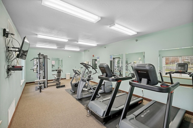 gym featuring carpet flooring and a textured ceiling