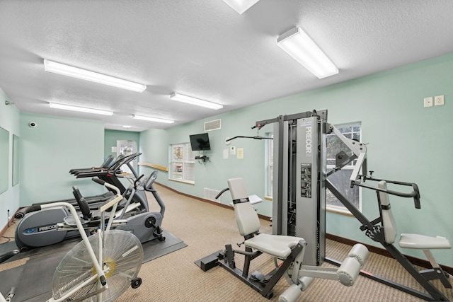 workout area with a textured ceiling and carpet floors