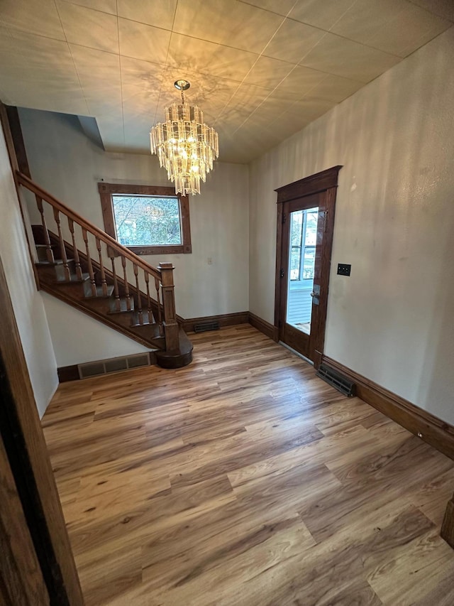 entryway with hardwood / wood-style flooring and a notable chandelier