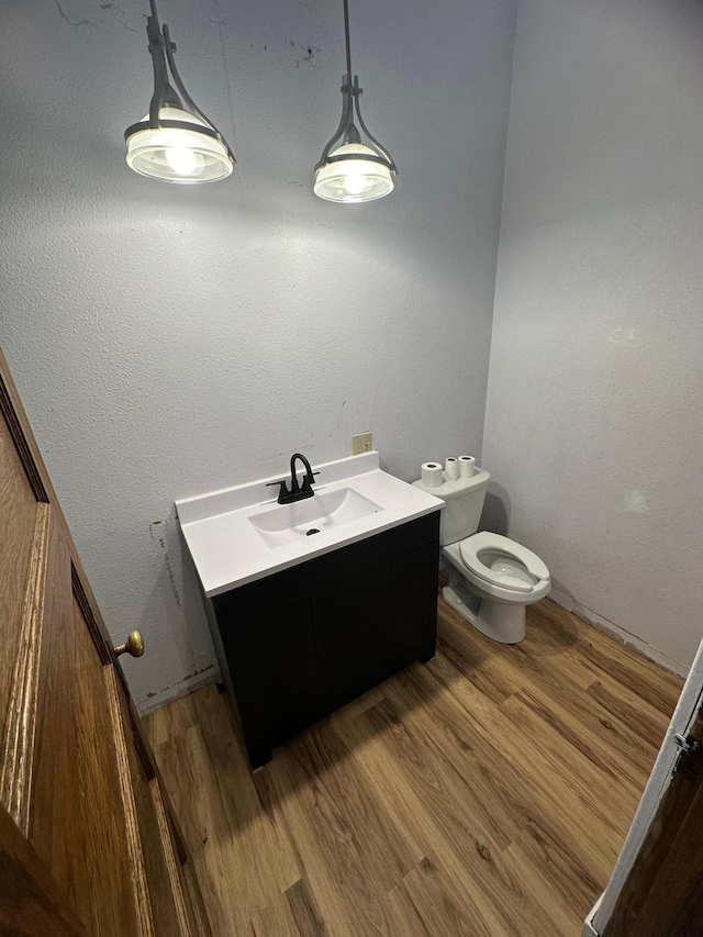 bathroom featuring toilet, vanity, and hardwood / wood-style flooring