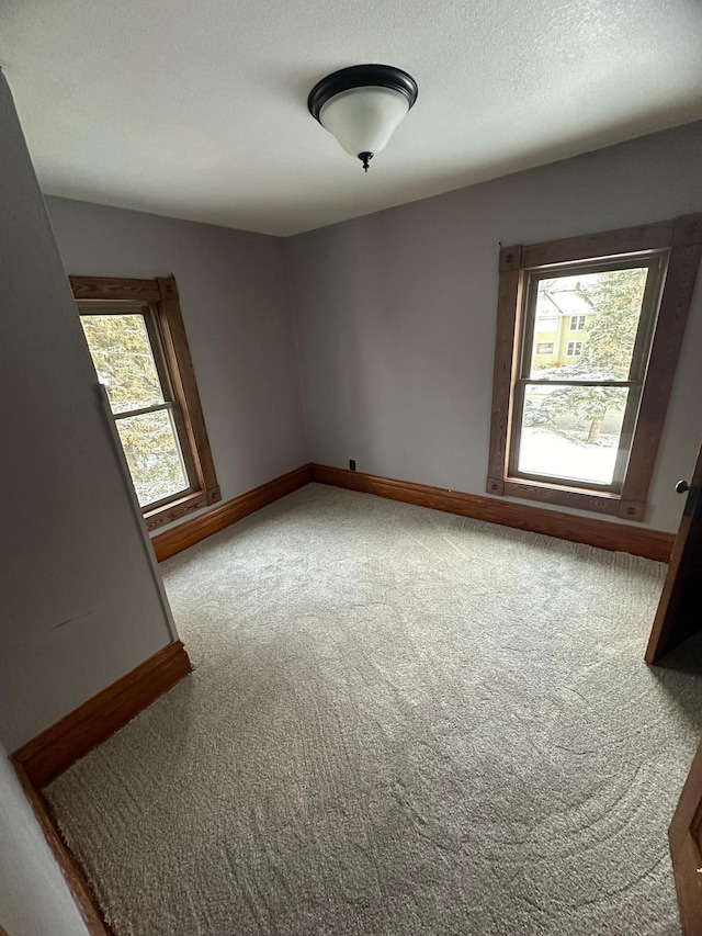 carpeted spare room featuring a textured ceiling