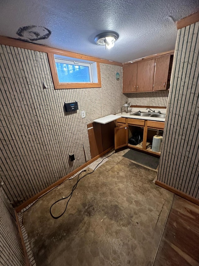 laundry room featuring sink, a textured ceiling, and wooden walls