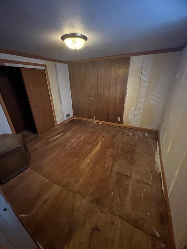 bedroom with wood-type flooring and wooden walls