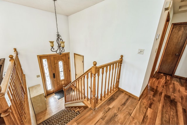 entryway with dark hardwood / wood-style floors, a high ceiling, and a chandelier