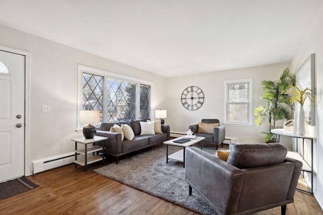 living room featuring hardwood / wood-style floors, baseboard heating, and a healthy amount of sunlight